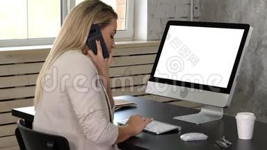 年轻的女接待员在办公室打电话，看着她电脑的<strong>显示器</strong>。 白色<strong>显示器</strong>。